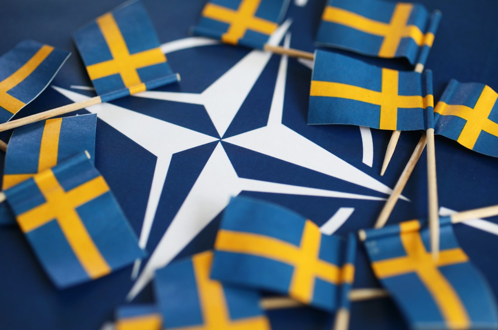 In this photo taken in Sweden&#039;s Motala on May 17, 2022, the Swedish national flags encircle the symbol of NATO. (Shutterstock Photo)