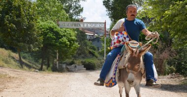 Metin Uğur is seen with his books on his donkey in Karacaören, Tokat, Türkiye, July 11, 2023. (DHA Photo)