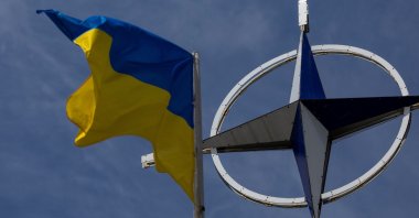 A Ukrainian national flag rises in front of the NATO emblem, in Kyiv, Ukraine, July 11, 2023. (Reuters Photo)