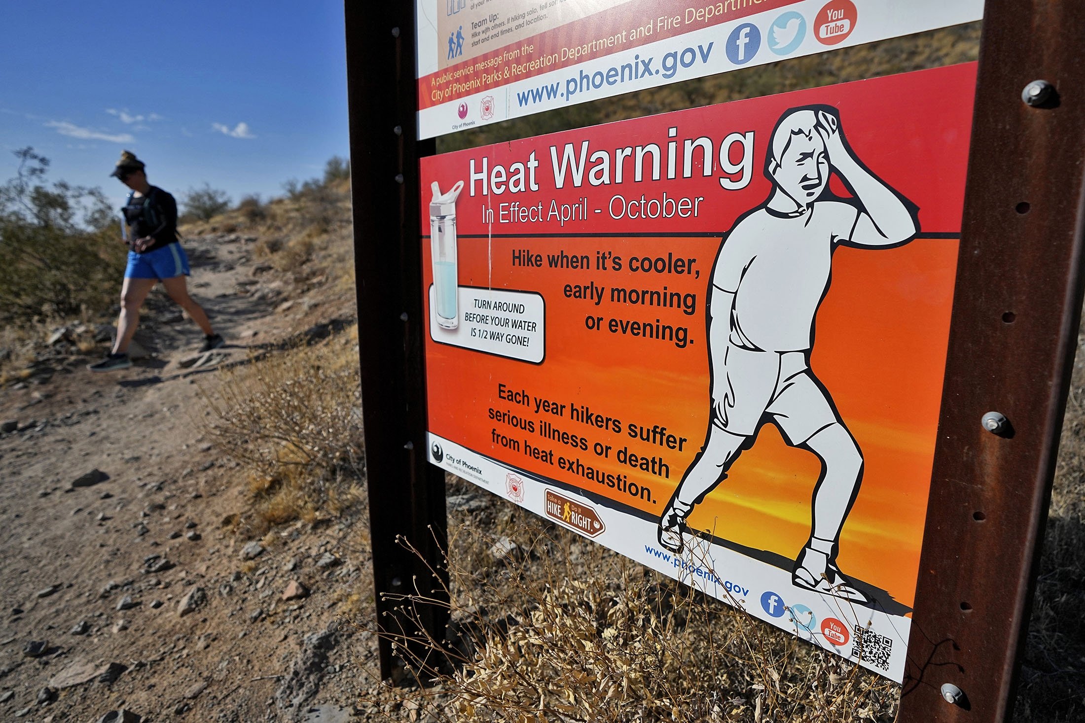Seorang pejalan kaki menyelesaikan pendakiannya lebih awal untuk mengalahkan suhu tinggi, di Phoenix, AS, 10 Juli 2023. (Foto AP)