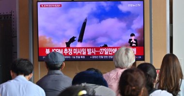 People watch a television screen showing a news broadcast with file footage of a North Korean missile test, Seoul, South Korea, July 12, 2023. (AFP Photo)