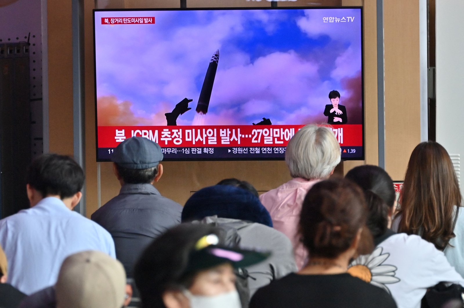 People watch a television screen showing a news broadcast with file footage of a North Korean missile test, Seoul, South Korea, July 12, 2023. (AFP Photo)