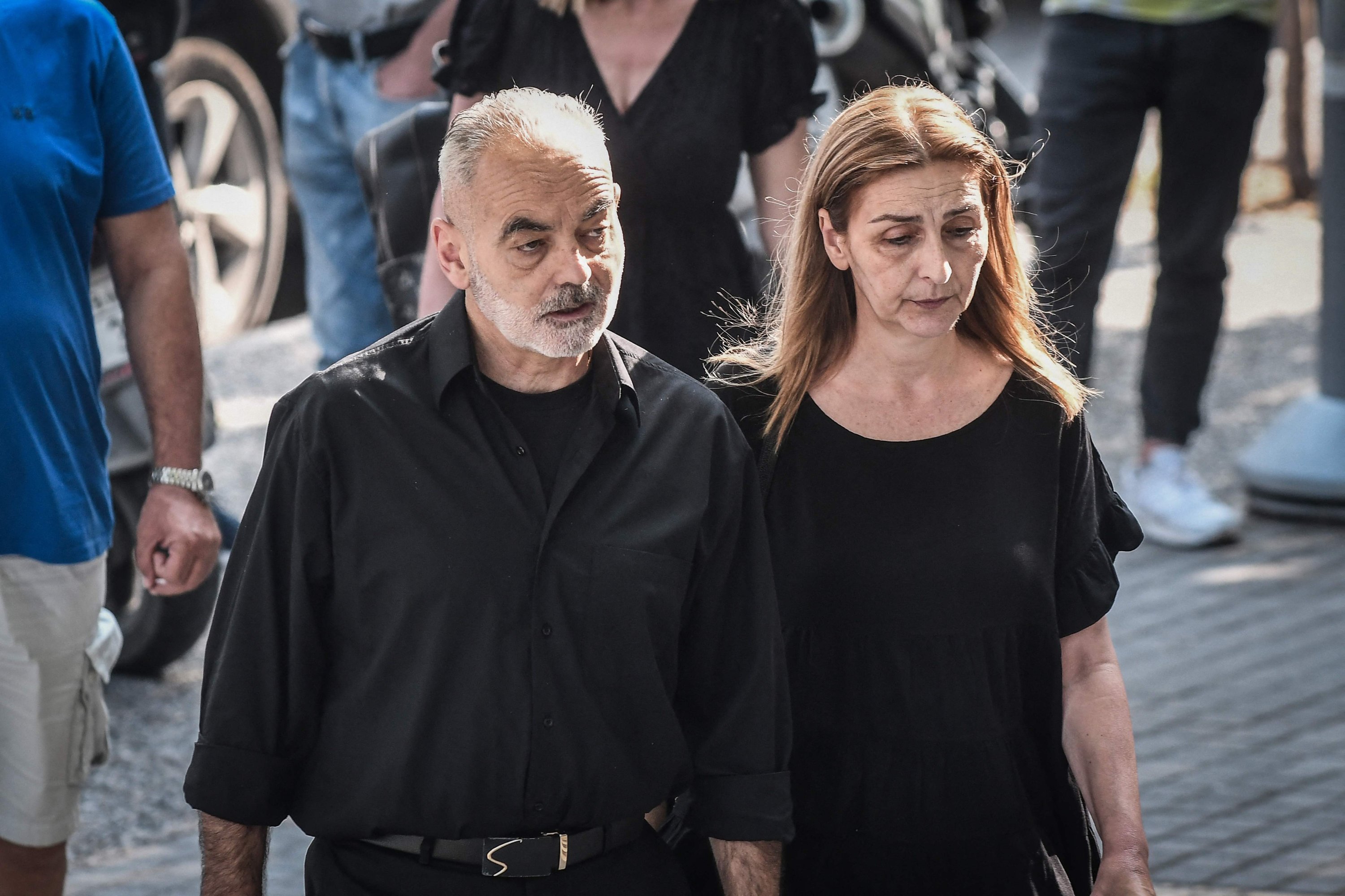 Orang tua mendiang penggemar sepak bola Alkis Kampanos, pendukung berusia 19 tahun yang dipukuli hingga tewas pada Februari 2022, tiba di gedung pengadilan, Thessaloniki, Yunani, 12 Juli 2023. (AFP Photo)