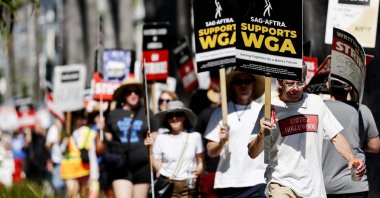 A sign reads "SAG-AFTRA Supports WGA" as SAG-AFTRA members walk the picket line in solidarity with striking WGA (Writers Guild of America) workers outside Netflix offices in Los Angeles, California, U.S., July 13, 2023. (AFP Photo)
