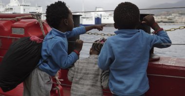 Children wave at a boat from aboard the Ocean Viking as it reaches the port of Messina, Italy, Sept. 24, 2019. (AP Photo)