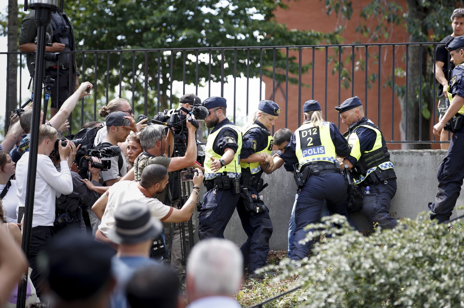 Police members try to restrain a man outside Stockholm&#039;s mosque at Medborgarplatsen, Sweden, June 28, 2023. (TT News Agency via AP)