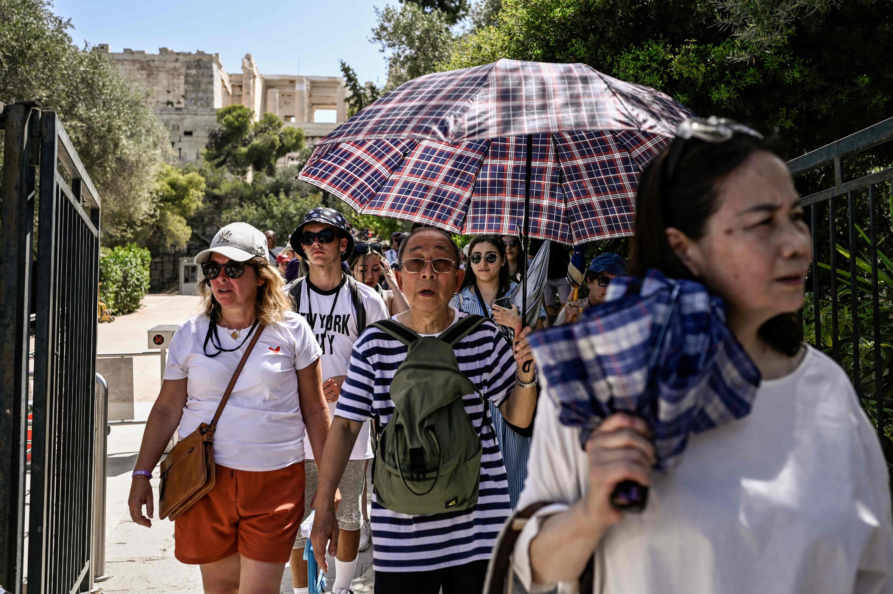 Pengunjung meninggalkan situs arkeologi Acropolis di Athena, Yunani, 14 Juli 2023. (Foto AFP)