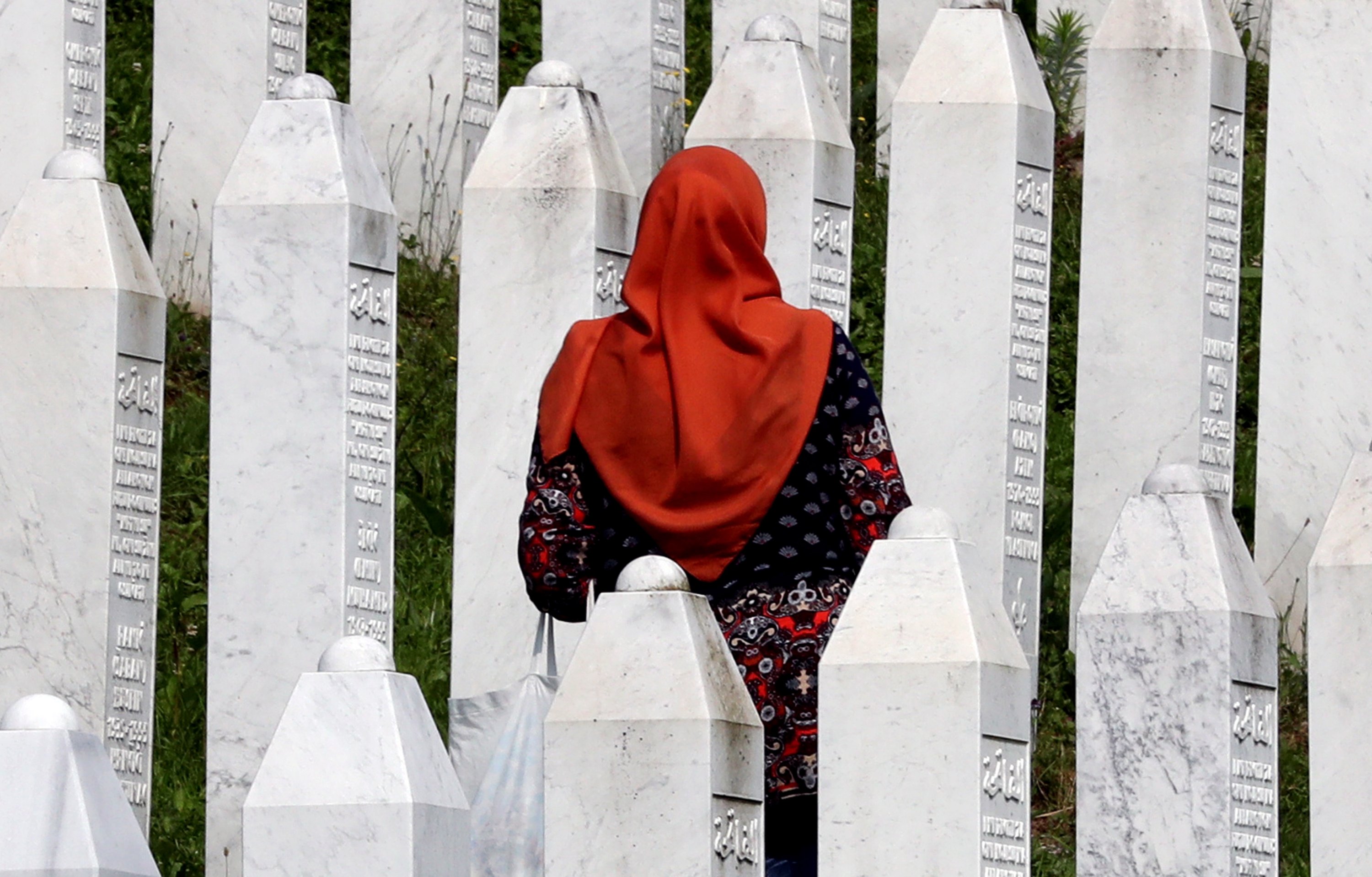 Seorang wanita Muslim Bosnia mengunjungi batu nisan selama upacara pemakaman untuk 30 korban Muslim Bosnia yang baru diidentifikasi, di Pusat Peringatan dan Pemakaman Potocari, di Srebrenica, Bosnia-Herzegovina, 11 Juli 2023. (Foto EPA)