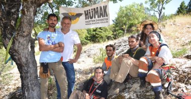 The members of HÜMAK are seen in a group photo close to the cave, Antalya, southern Türkiye, July 17, 2023. (IHA Photo)