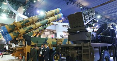 Visitors of the IDEF, the International Defense Industry Fair in Istanbul, talk next to Turkish-made rocket launchers, Wednesday, May 10, 2017. (AP File Photo)