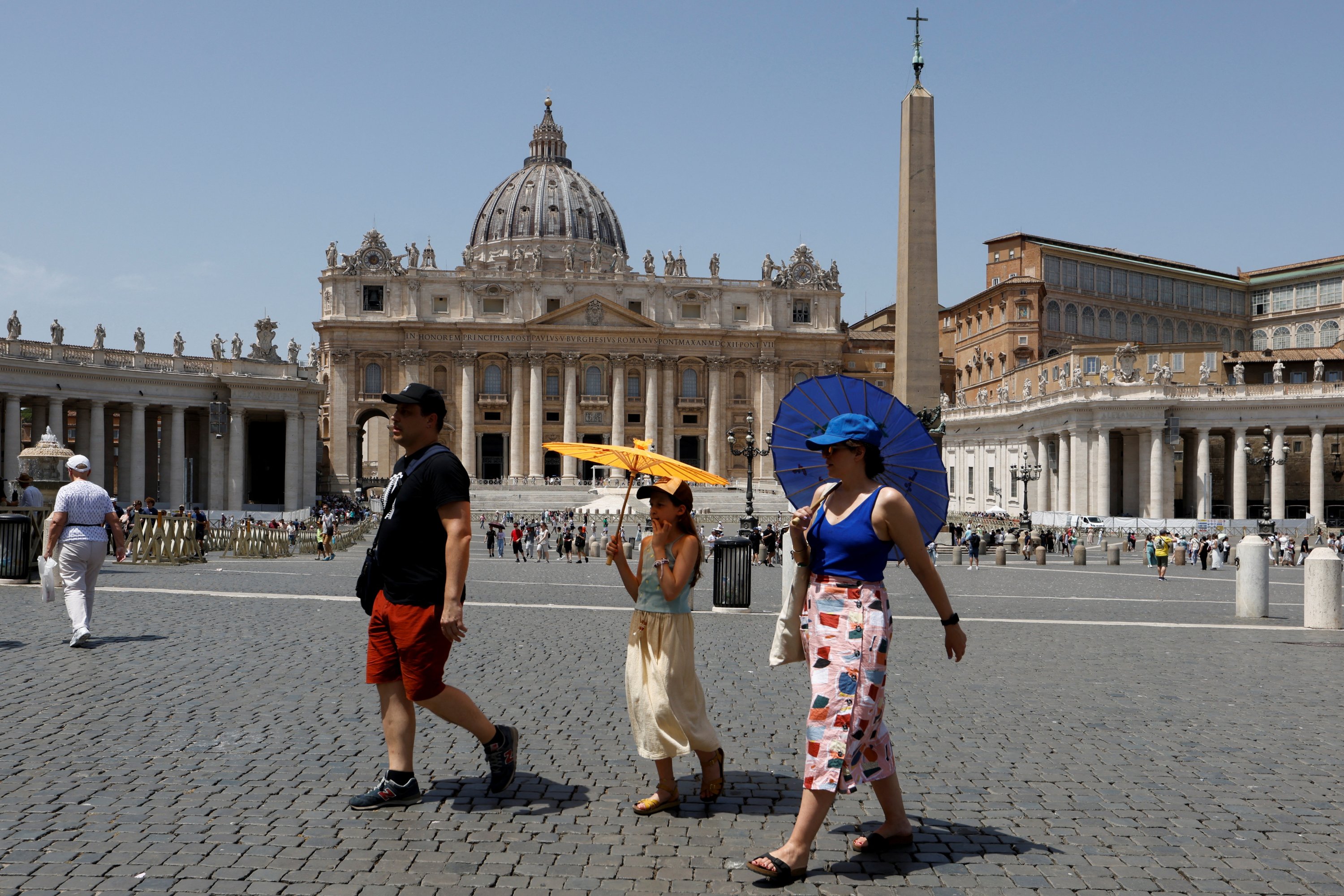 Orang-orang berlindung dari matahari saat mereka berjalan di luar Basilika Santo Petrus, Italia, di Vatikan, 19 Juli 2023. (Foto Reuters)