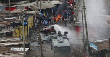 Protesters throw rocks at police during clashes next to a cloud of teargas in the Kibera area of Nairobi, Kenya, July 19, 2023. (AP Photo)