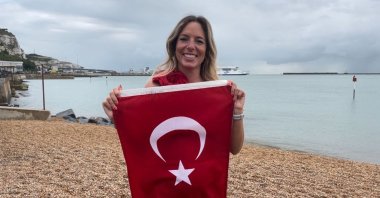 Turkish swimmer Deniz Kayadelen shows off the Turkish flag after swimming across the English Channel, Strouanne, France, July 20, 2023. (DHA Photo)
