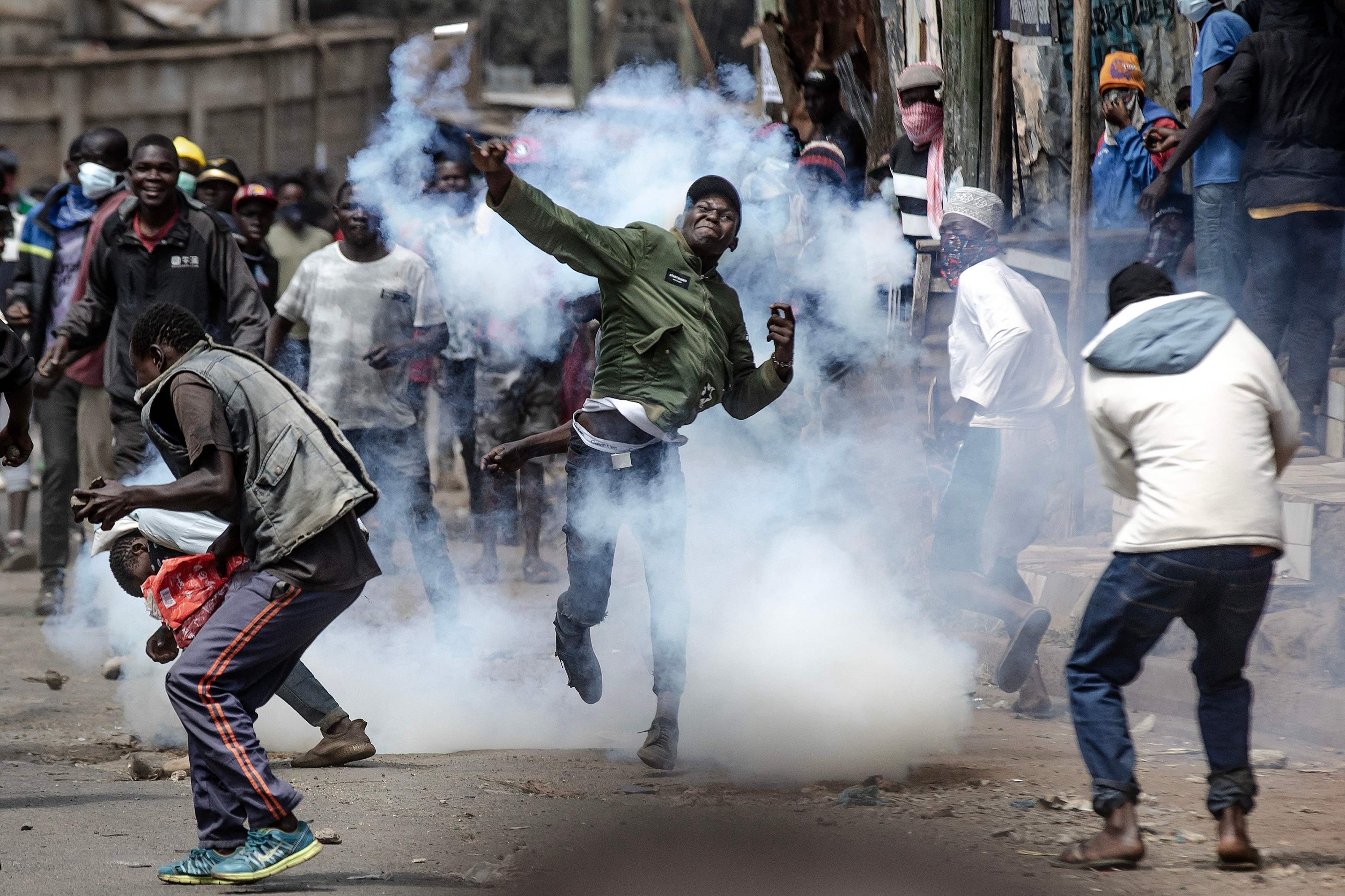 Seorang pendukung oposisi melempar tabung gas air mata yang ditembakkan oleh polisi anti huru hara saat bentrok dengan petugas polisi Kenya pada hari ketiga protes anti pemerintah, Nairobi, Kenya, 21 Juli 2023. (AFP Photo)