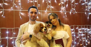 Mete Soyutürk (L) and Daria Soyutürk with their pet dogs pose at their wedding ceremony in Mersin, Türkiye, July 21, 2023. (IHA Photo)