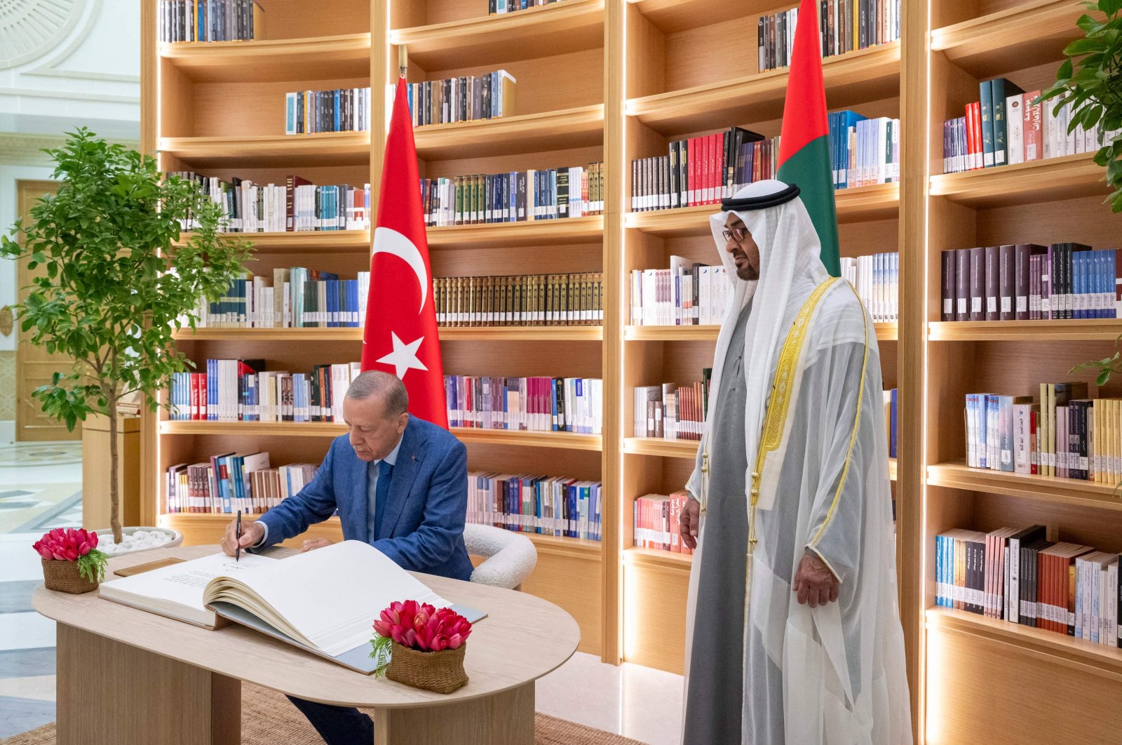 United Arab Emirates (UAE) President Sheikh Mohammed bin Zayed Al Nahyan (R) looks on as President Recep Tayyip Erdoğan signs the guest book during an official reception in Abu Dhabi, UAE, July 19, 2023. (AFP Photo)