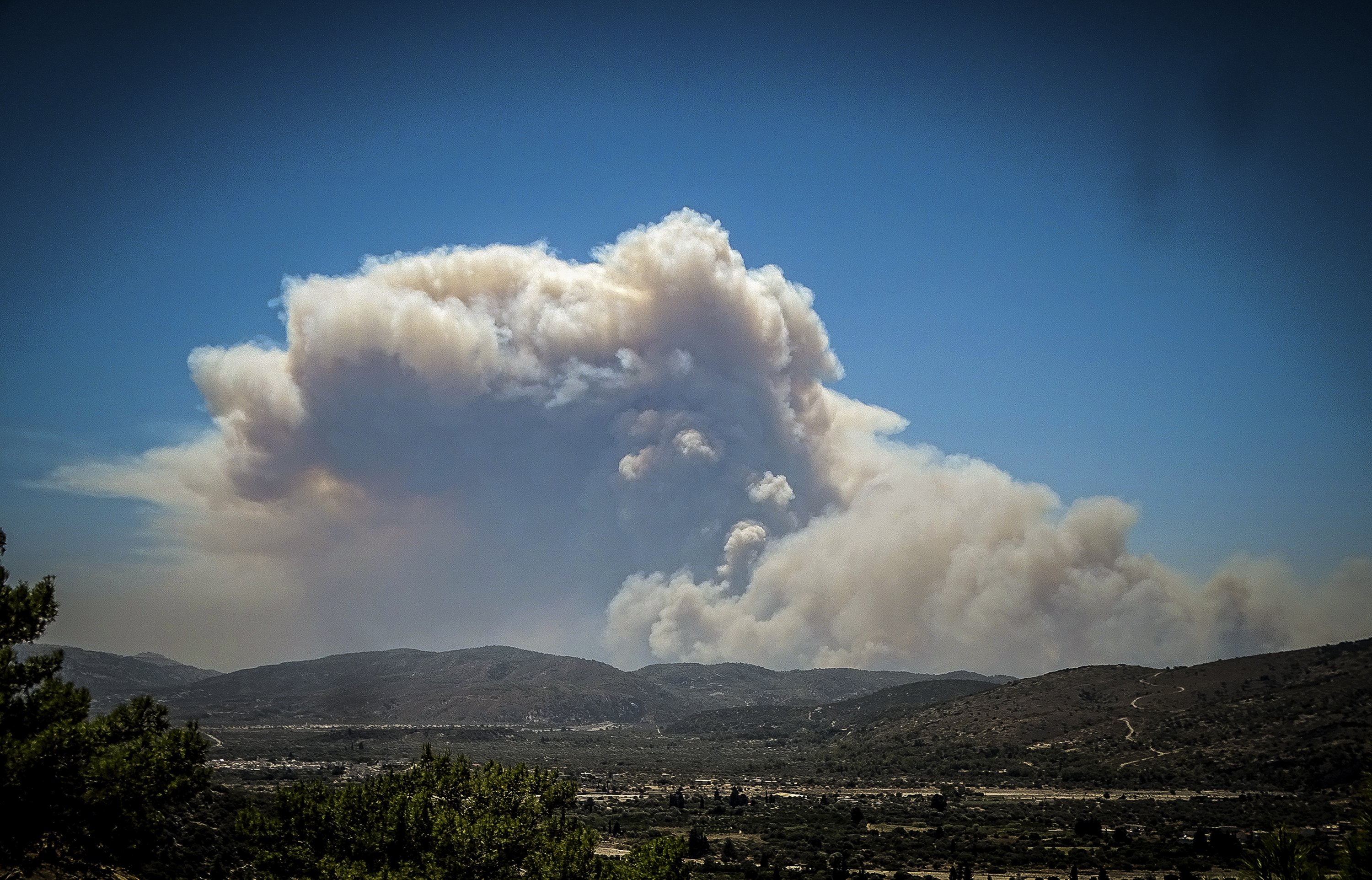 Kepulan asap dari kebakaran hutan membubung di atas pulau Rhodes, Yunani, 22 Juli 2023. (Foto AP)