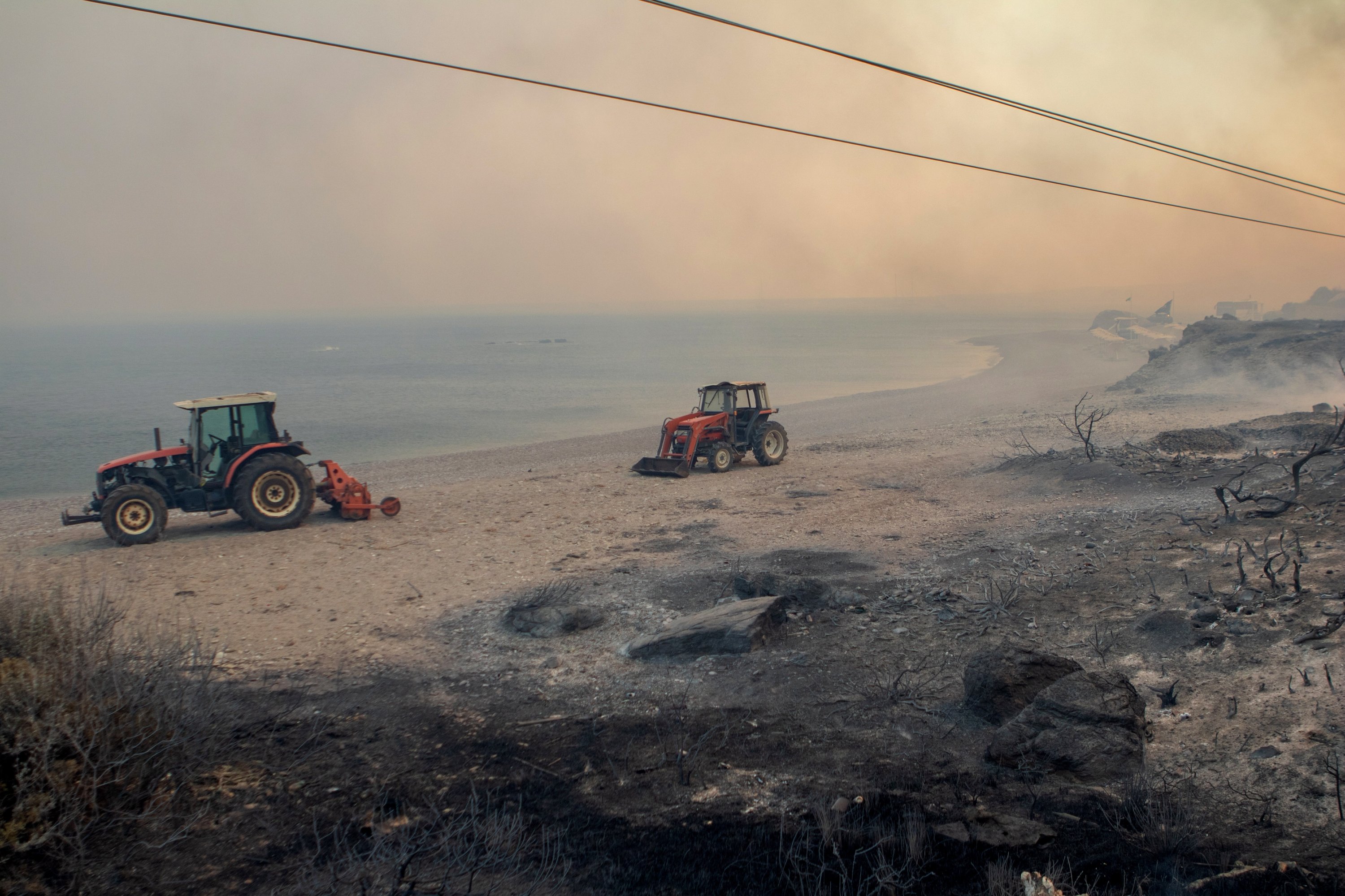 Τraktor beroperasi saat kebakaran hutan di desa Kiotari, di pulau Rhodes, Yunani, 22 Juli 2023. (Foto EPA)