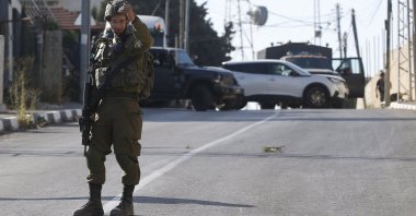 An Israeli soldier stands at the area where three Palestinians were shot dead near Nablus, occupied West Bank, Palestine, July 25, 2023. (EPA Photo)