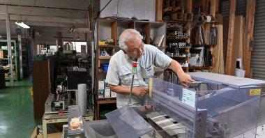 Kiyoshi Hashimoto, president of the machinery factory J&amp;A Sakura, looking at equipment at his factory in Yachimata, Chiba prefecture, Japan, June 20, 2023. (AFP Photo)