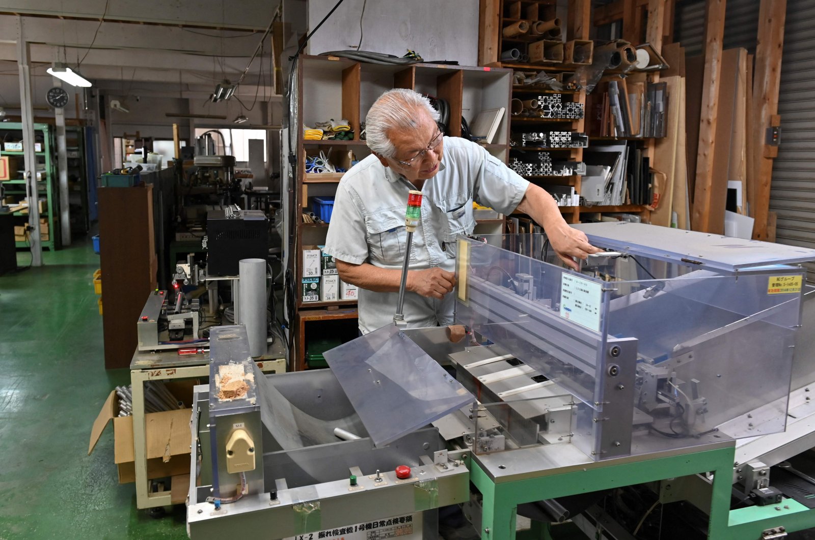Kiyoshi Hashimoto, president of the machinery factory J&amp;A Sakura, looking at equipment at his factory in Yachimata, Chiba prefecture, Japan, June 20, 2023. (AFP Photo)