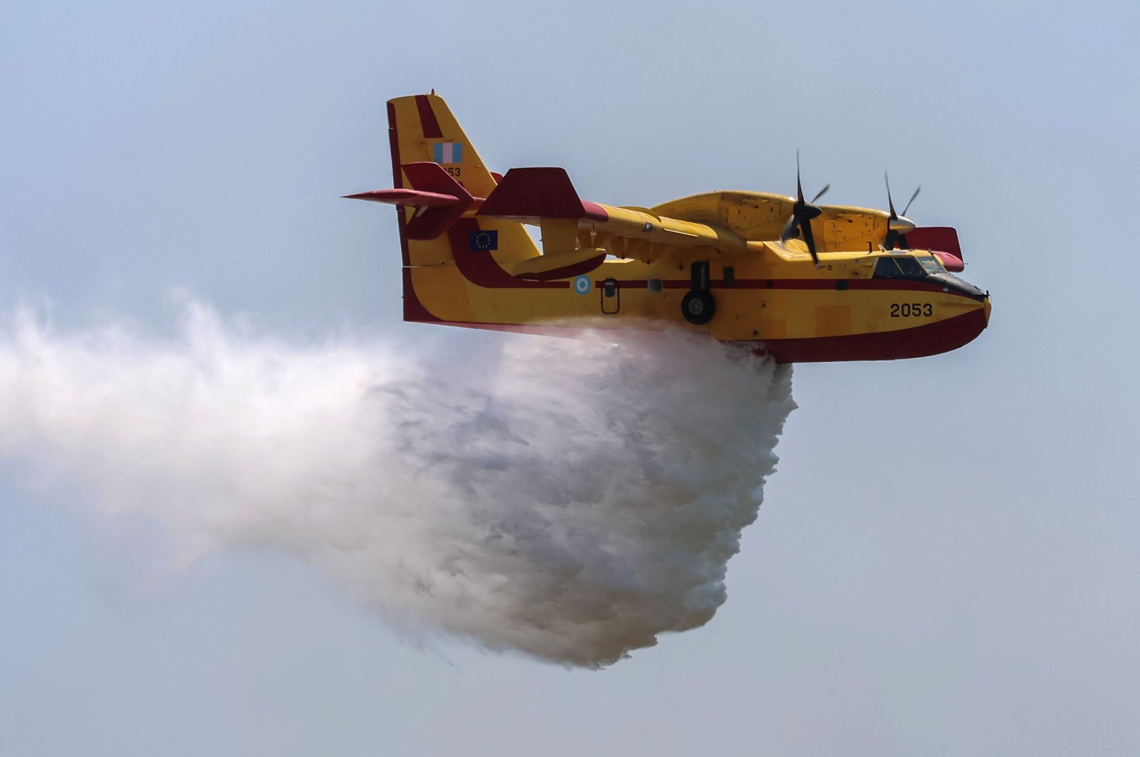 A firefighting plane makes a water drop, as a wildfire burns near the village of Vati, on the island of Rhodes, Greece, July 25, 2023. (Reuters Photo)