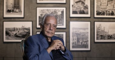 Hailed photographer Izzet Keribar poses with examples of his photography, Istanbul, Türkiye, July 7, 2023. (AA Photo)