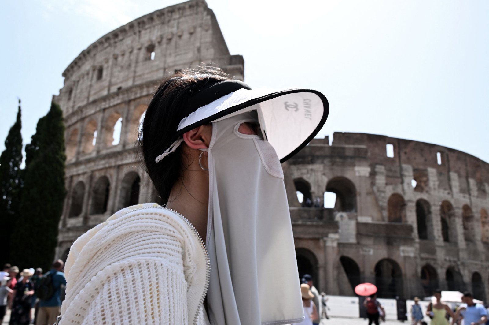 A tourist shelters from the sun with a sun protection clothing near the Colosseum in Rome, Italy, July 24, 2023. (AFP Photo)