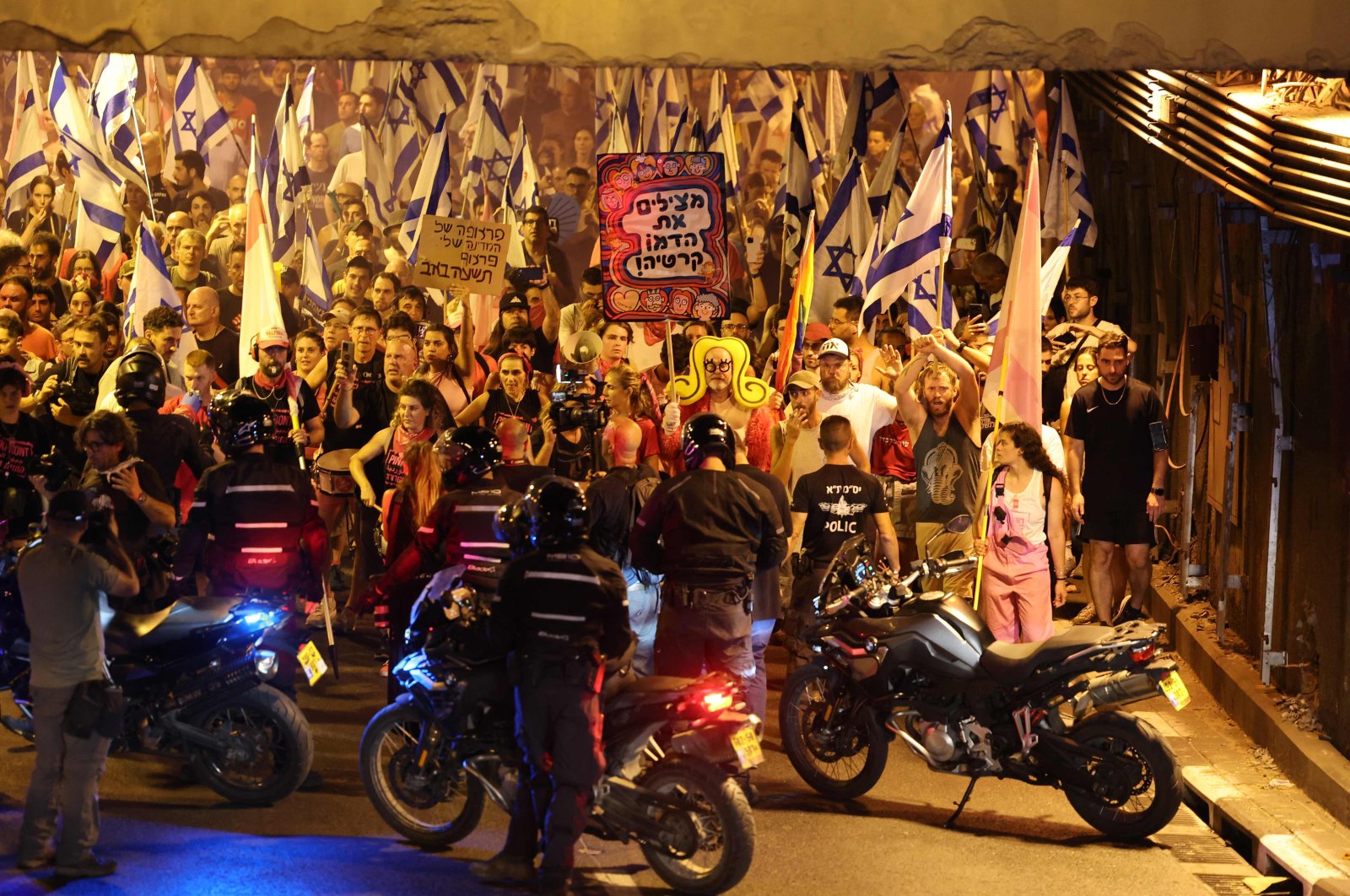 Demonstrators wave the Israeli flag during a march against the government&#039;s judicial reform plan in Tel Aviv, Israel, July 27, 2023. (AFP Photo)