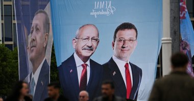 People walk in front of the banners of President Tayyip Erdoğan (L) and Kemal Kılıçdaroğlu (C), presidential candidate of the main opposition alliance with Istanbul Mayor Ekrem Imamoğlu (R), ahead of the May 14 presidential and parliamentary elections, in Istanbul, Türkiye, May 12, 2023. (Reuters Photo)
