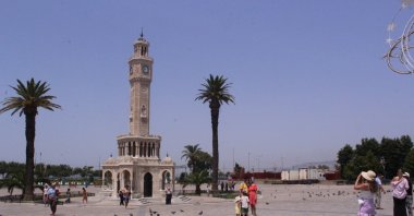 Citizens pass by the historic Clock Tower amid extreme heat, Izmir, western Türkiye, July 26, 2023. (IHA Photo)