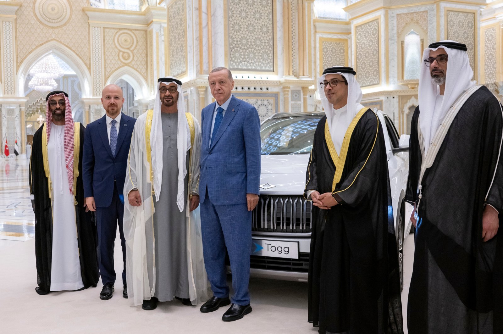 Sheikh Mohammed bin Zayed Al Nahyan (center L), president of the United Arab Emirates, and President Recep Tayyip Erdoğan (center R) pose for a photograph in front of a Togg car; an electrical Turkish manufactured vehicle during an official reception, at Qasr Al Watan in Abu Dhabi, United Arab Emirates, July 19, 2023. (Reuters Photo)