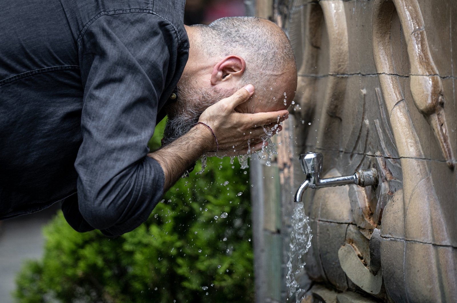 A man washes his head to cool off in sweltering heat, in Ankara, Türkiye, July 27, 2023. (AA Photo)