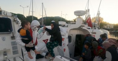Coast guard officers escort rescued migrants to the shore, in Çanakkale, northwestern Türkiye, July 31, 2023. (AA Photo)