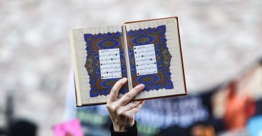 A protester holds a copy of the Quran as they attend a protest against Sweden for allowing anti-Muslim right-wing extremists to desecrate and burn copies of the Muslim holy book in Stockholm and Copenhagen, in front of the Consulate General of Sweden in Istanbul, Türkiye, July 30, 2023. (EPA Photo)