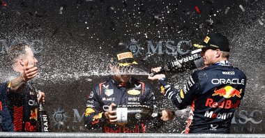 Winner Red Bull Racing&#039;s Dutch driver Max Verstappen (R) and second-placed Red Bull Racing&#039;s Mexican driver Sergio Perez (C) celebrate with a team member on the podium after the Formula One Belgian Grand Prix at the Spa-Francorchamps Circuit, Spa, Belgium, July 30, 2023. (AFP Photo)