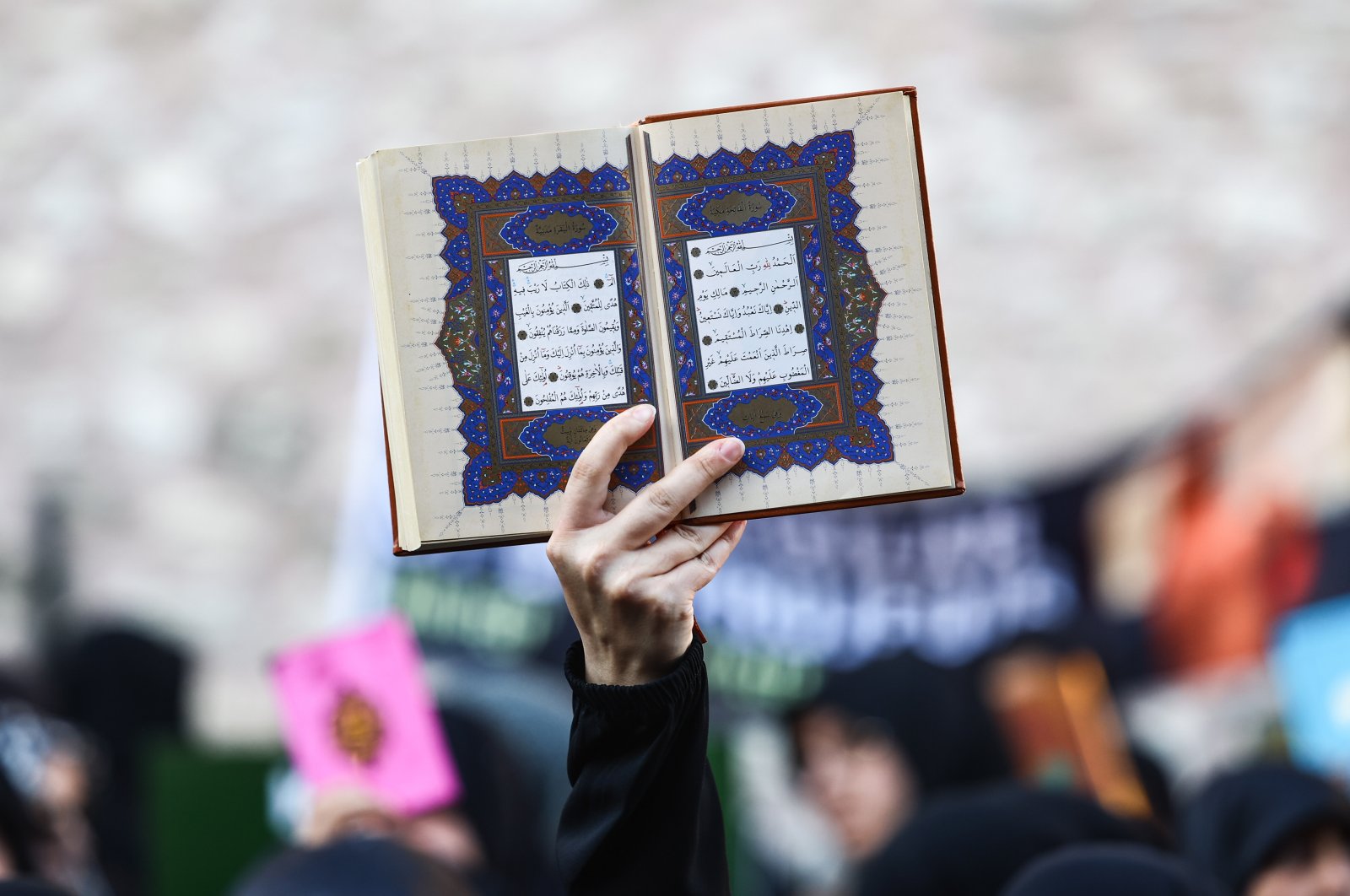 A protester holds a copy of the Quran as they attend a protest against Sweden for allowing anti-Muslim right-wing extremists to desecrate and burn copies of the Muslim holy book in Stockholm and Copenhagen, in front of the Consulate General of Sweden in Istanbul, Türkiye, July 30, 2023. (EPA Photo)