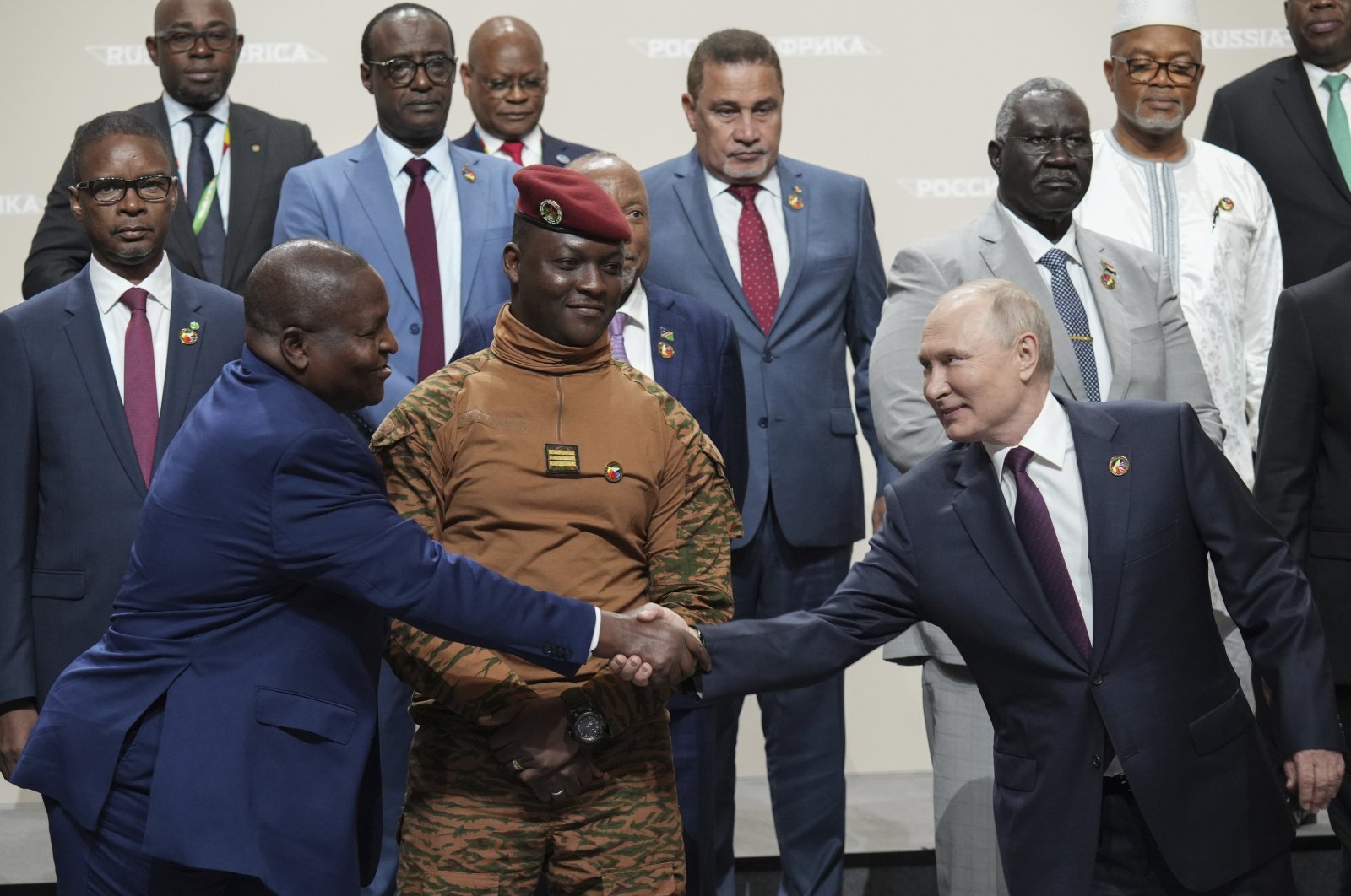 Russian President Vladimir Putin (R) and Mozambique President Filipe Nyusi shake hands during a family photo opportunity during the Russia Africa Summit in St. Petersburg, Russia, July 28, 2023. (AP Photo)