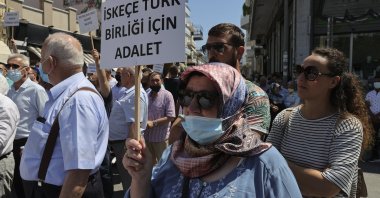 A Turkish Greek woman holds up a sign that reads "Justice for Turkish community of Iskeçe (Xanthi)" during a protest against the Greek Supreme Court's rejection of the community's reregistration in contravention of European Court of Human Rights (ECtHR) rulings, Western Thrace, Greece, July 12, 2021. (AA Photo)