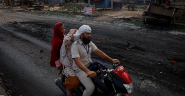 A family rides on a motorcycle on a deserted road during a curfew following Hindu-Muslim clashes in Nuh, Haryana, northern India, Aug. 1, 2023. (Reuters Photo)