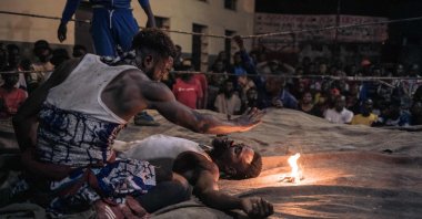 A voodoo wrestler whispers incantations over his opponent during a fight in a schoolyard in Selemenbao district, Kinshasa, Democratic Republic of Congo, July 29, 2023. (AFP Photo)