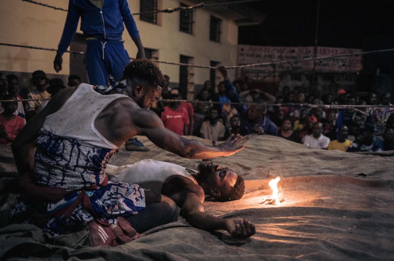 A voodoo wrestler whispers incantations over his opponent during a fight in a schoolyard in Selemenbao district, Kinshasa, Democratic Republic of Congo, July 29, 2023. (AFP Photo)