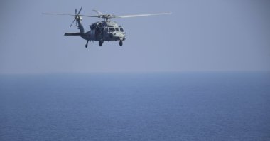 A U.S. MH-60 Seahawk helicopter flies over Iranian Revolutionary Guard patrol boats in the Strait of Hormuz, Dec. 21, 2018. (AP File Photo)