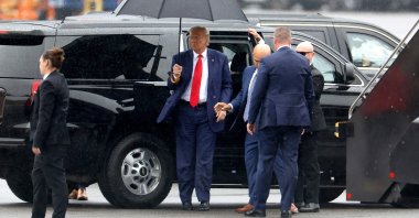 Former U.S. President Donald Trump holds an umbrella as he arrives at Reagan National Airport following an arraignment in a Washington, D.C. court in Arlington, Virginia, U.S., Aug. 3, 2023. (AFP Photo) 