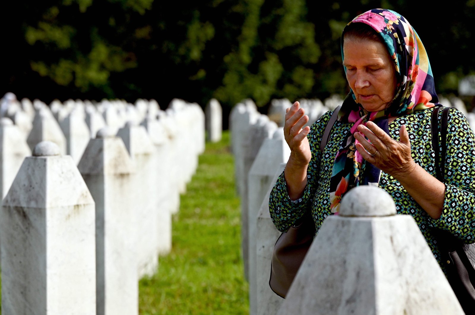 A Bosnian Muslim woman and survivor of the 1995 Srebrenica genocide mourns near the graves of relatives and victims, Srebrenica, Bosnia and Herzegovina, July 11, 2023. (AFP Photo)