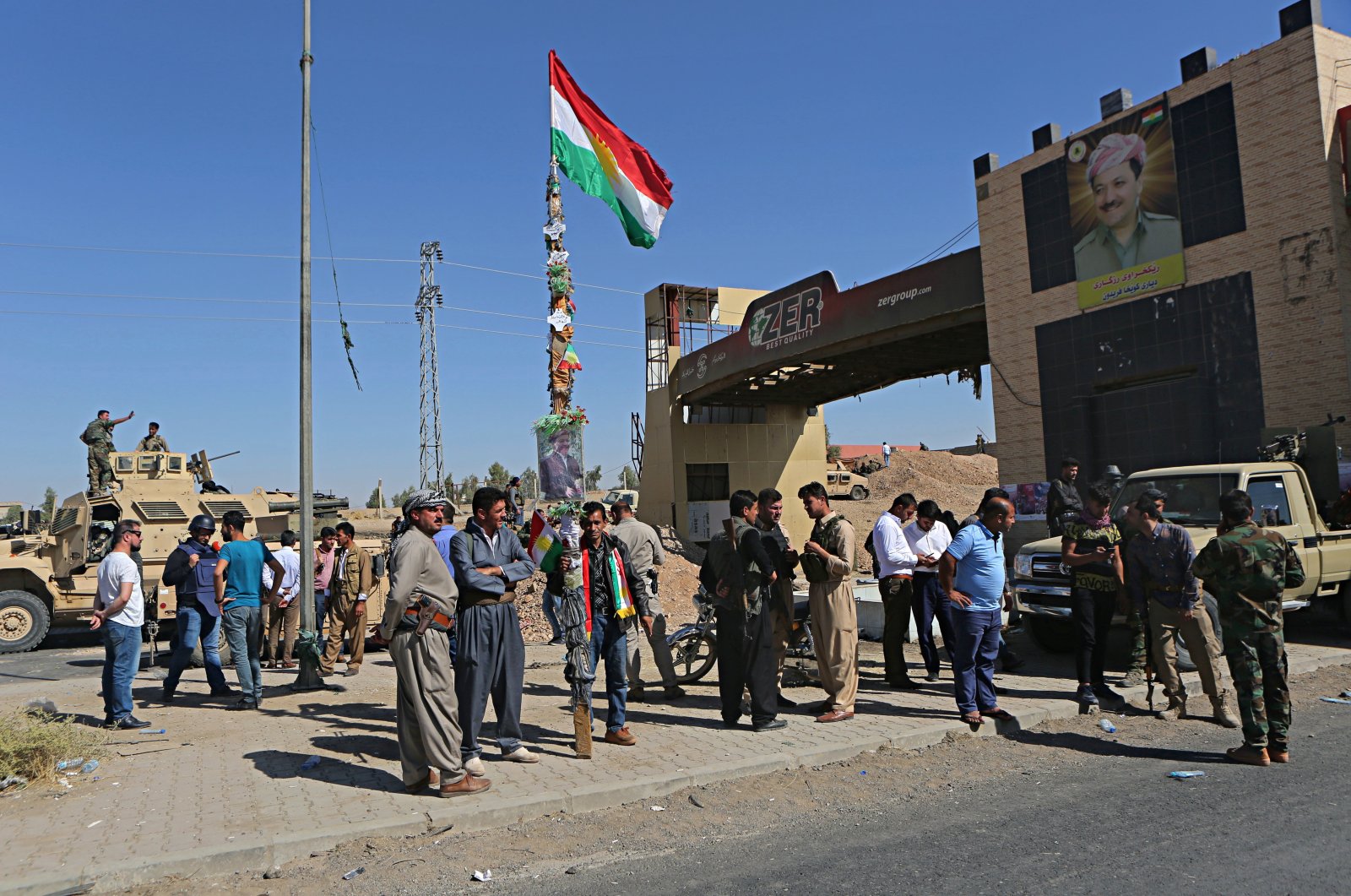 A picture of Massoud Barzani, the then-President of KRG, is displayed as security forces stand guard in Altun Kupri, on the outskirts of Irbil, Iraq, Thursday, Oct. 19, 2017. (AP File Photo)