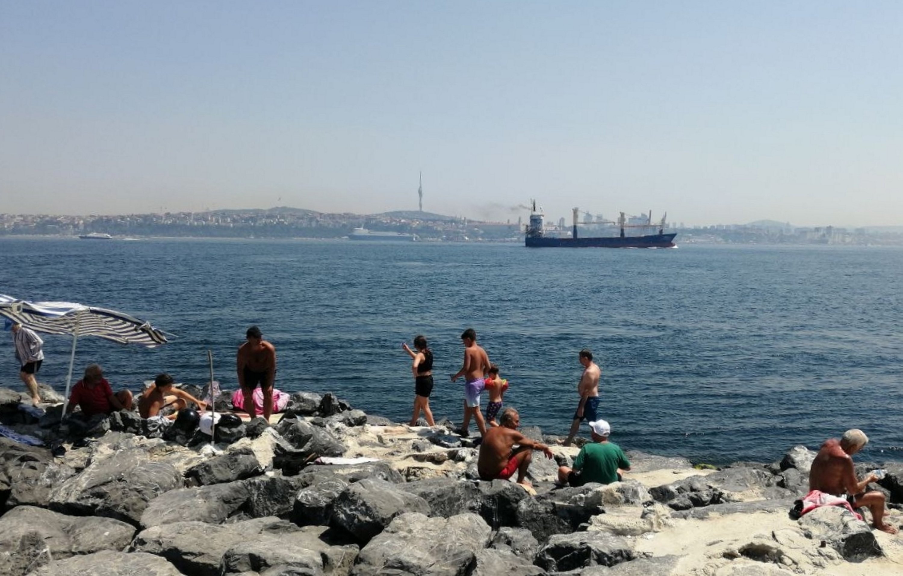 Residents overwhelmed by the 'eyyam-ı bahur' heat in Istanbul cool off at the beach overseeing the city's Anatolian part, Türkiye, Aug. 3, 2023. (AA Photo)