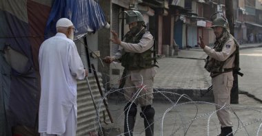 An elderly Kashmiri man is stopped before being allowed to pass near a temporary checkpoint set up by Indian paramilitary soldiers during lockdown in Srinagar, Indian controlled Kashmir, Friday, Aug. 23, 2019. (AP Photo)