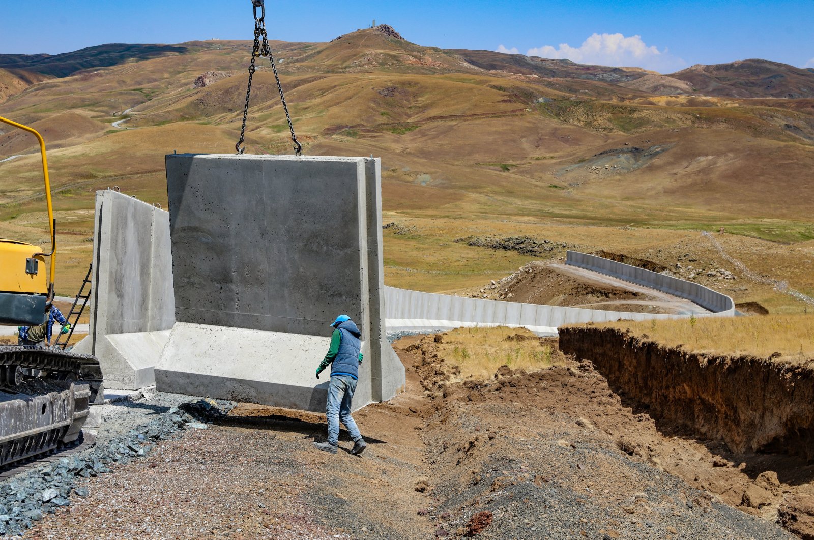 Workers install concrete blocks on the border wall, in Van, eastern Türkiye, July 17, 2023. (AA Photo) 
