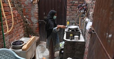 Lubna Babar, a former factory worker cooks during an interview with AFP at her house in Lahore, Pakistan, July 25, 2023. (AFP Photo)